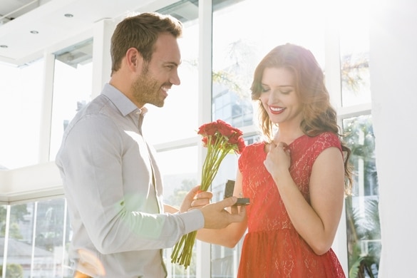 Young man offering flowers and engagement ring to beautiful woman - How to Get a Gemini Man to Marry You